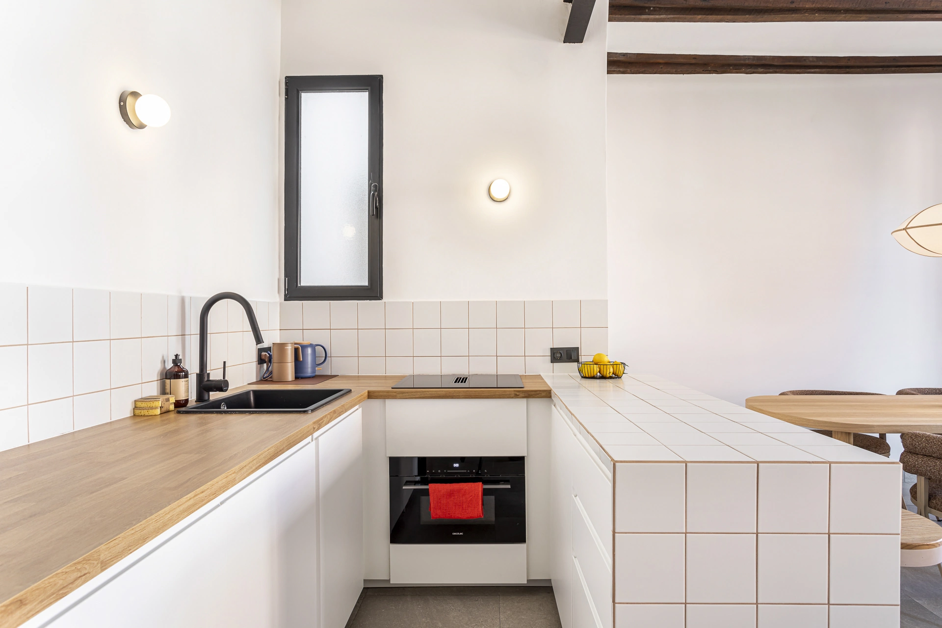 Cocina blanca con encimera de madera y frente de azulejo