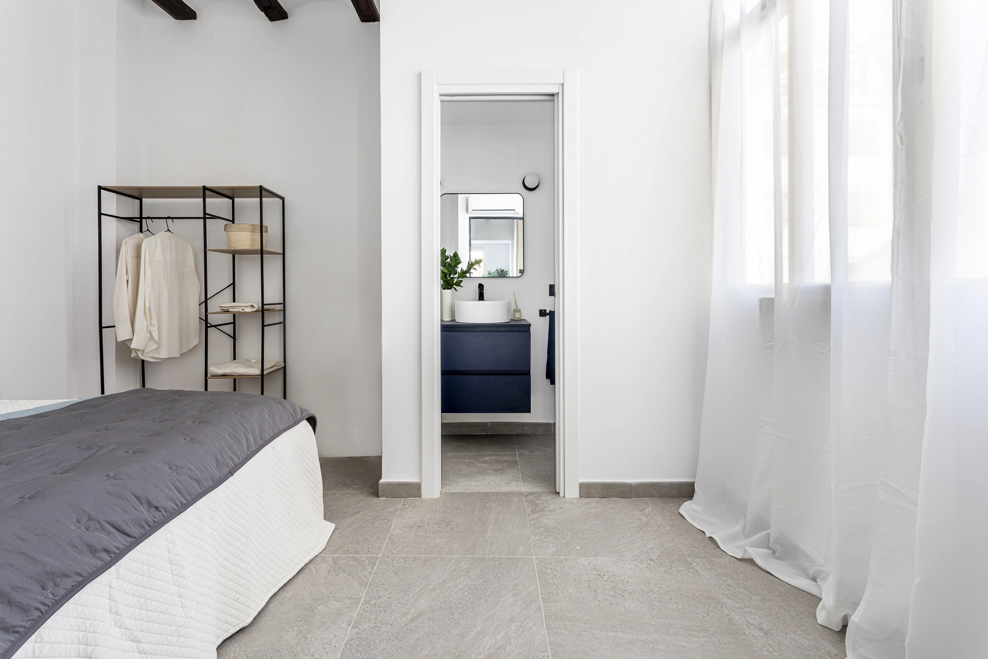 Dormitorio reformado conectado visualmente con el baño